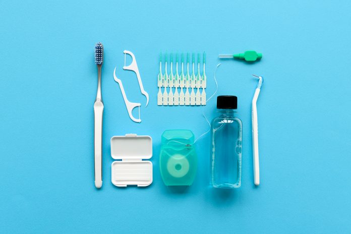 Different Tools For Dental Care On Blue Background. Toothbrush,